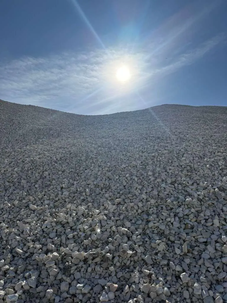 Mountain of aggregate material illuminated by natural sunlight